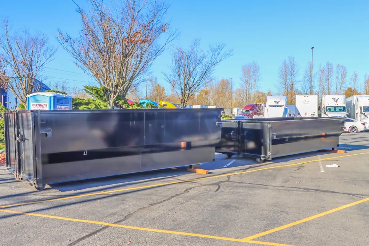 Professional dumpster rental service with roll-off container on residential driveway in Bellaire